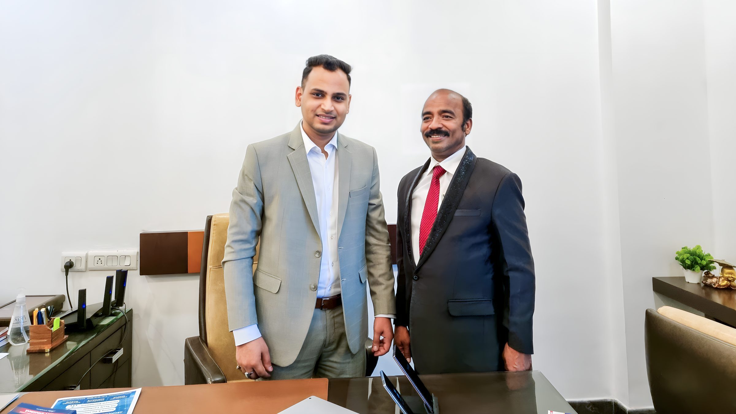 Lithvik Mukesh Sharma is photographed. Two men stand in an indoor office, smiling. Lithvik Mukesh Sharma is photographed. Two men stand in an enclosed office, smiling. The author of the book A SCIENTIST ON A SOCIAL MISSION, the older man on the right, is bald